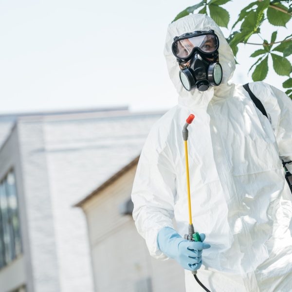 low angle view of pest control worker standing with sprayer